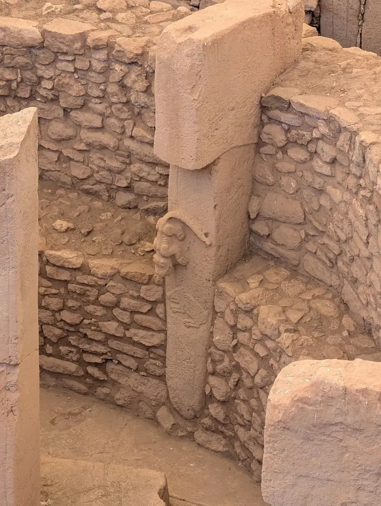 A predator carved in high relief on the side of a limestone pillar